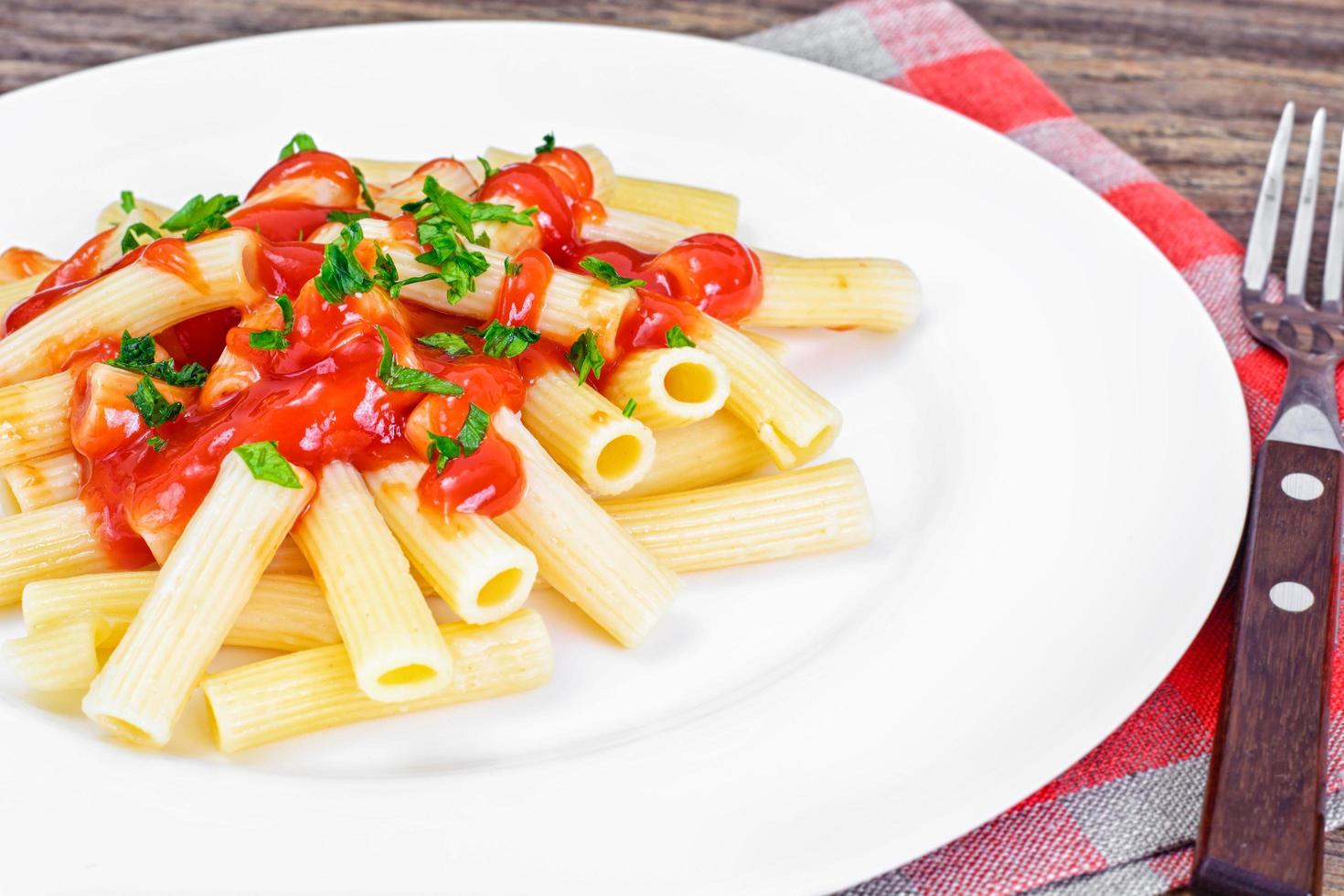 pasta med tomatketchupsås, salladslök och ost foto