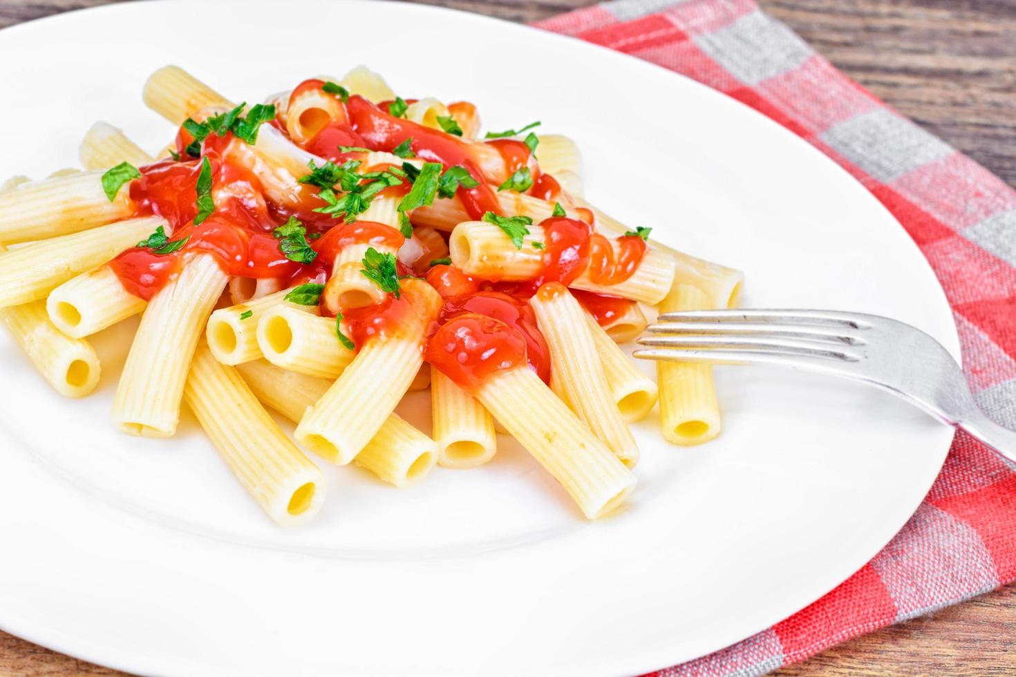 pasta med tomatketchupsås, salladslök och ost foto