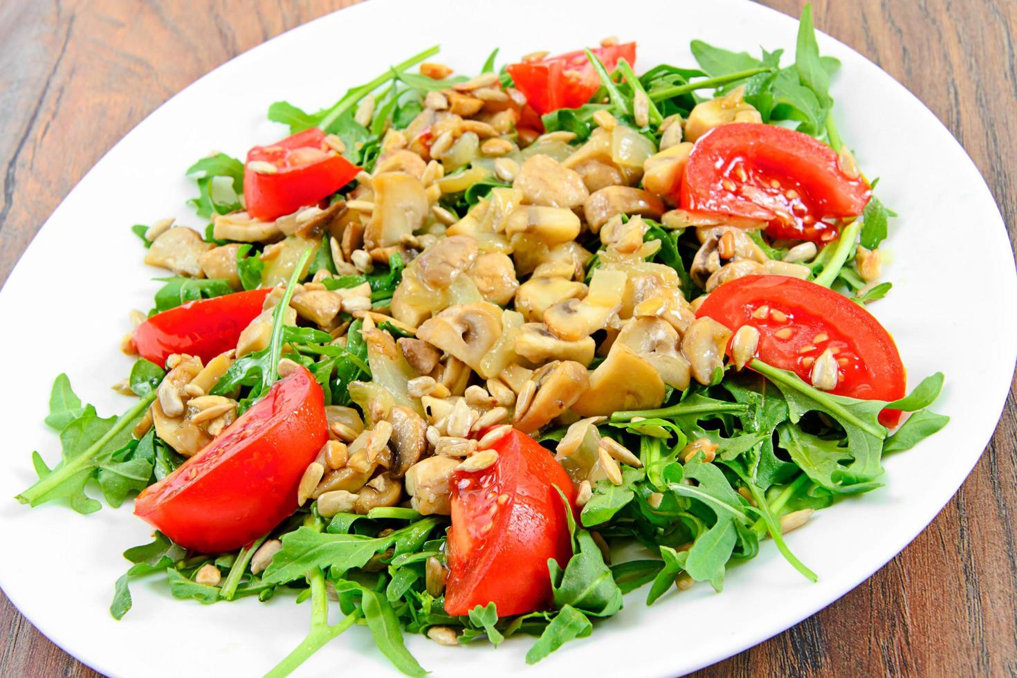 sallad med tomater, champinjoner, ruccola och frön foto