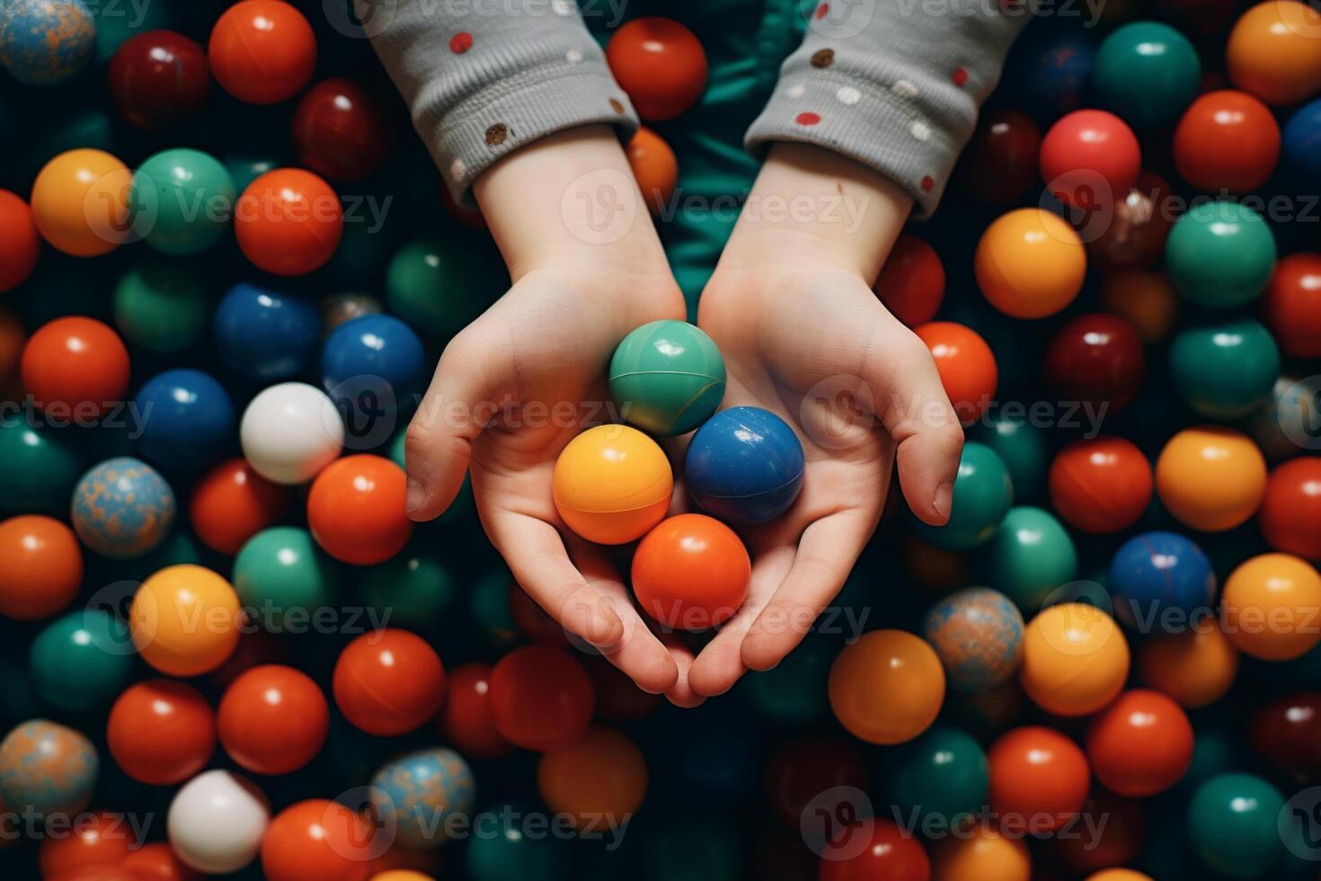 barn innehav plast färgrik bollar på lekplats. foto