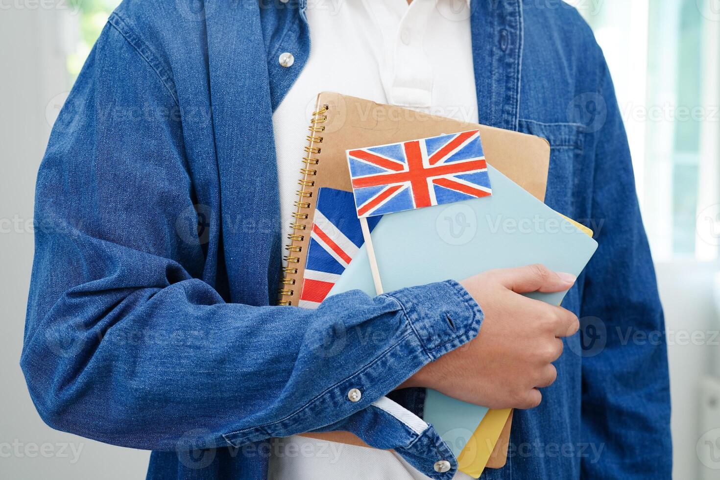 inlärning engelsk, asiatisk Tonårs studerande innehav bok med flagga för språk program utbildning. foto