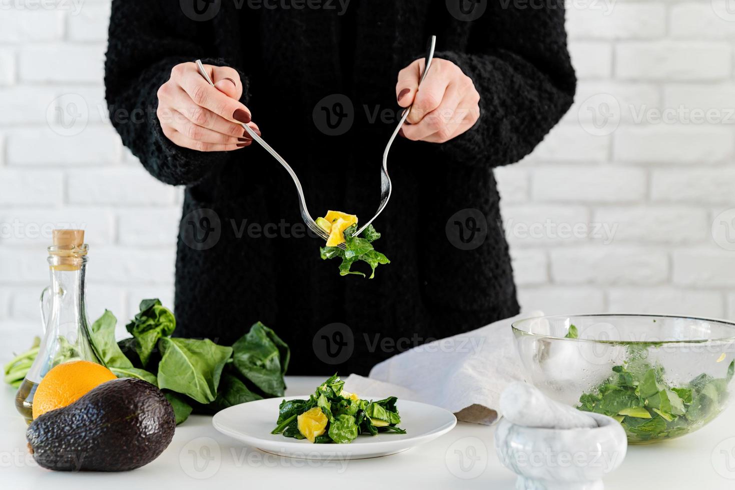 steg för steg beredning av spenat, avokado och apelsinsallad. steg 7 - lägg salladen på serveringsfatet foto