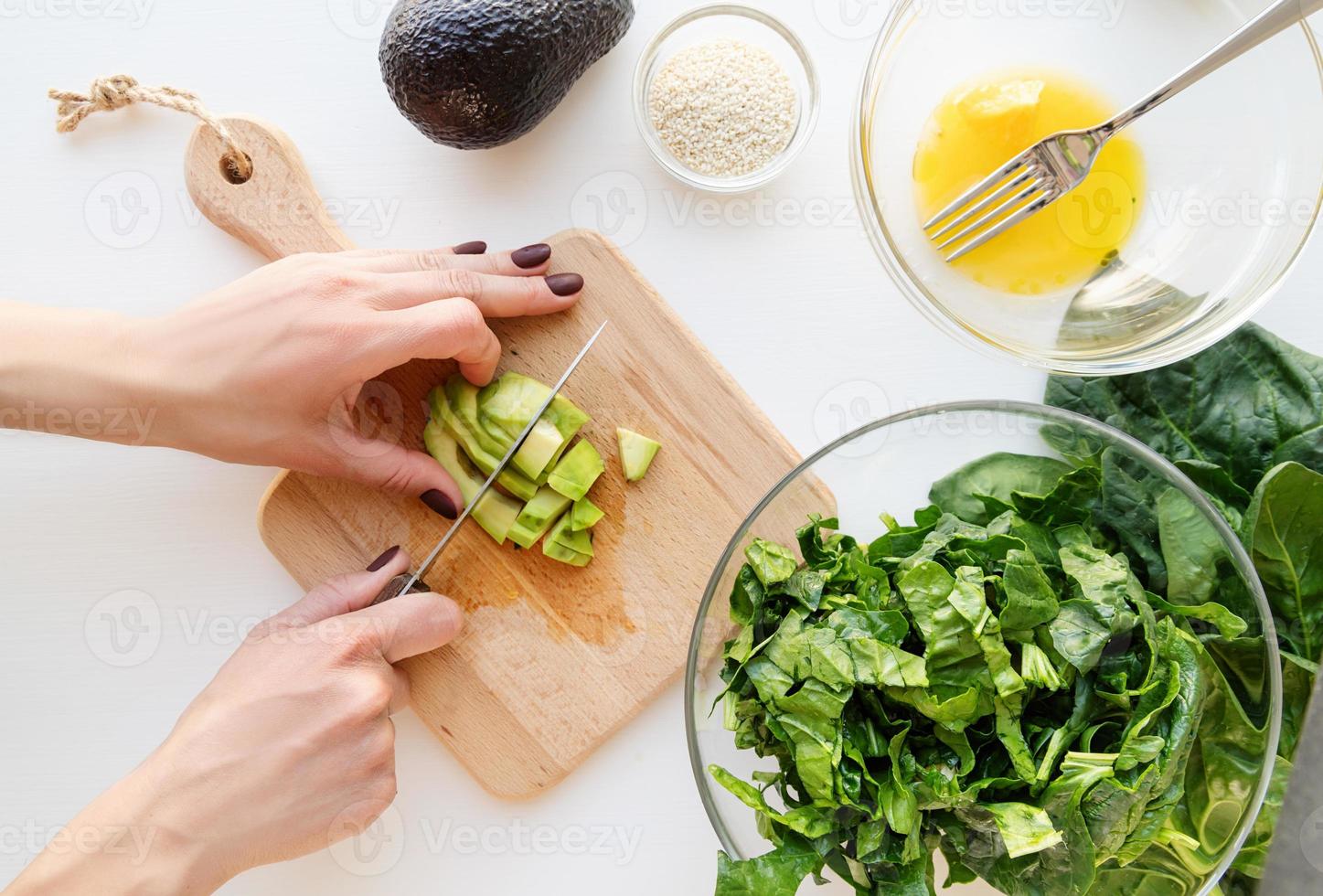 steg för steg beredning av spenat, avokado och apelsinsallad. steg 5 - skär avokadon foto