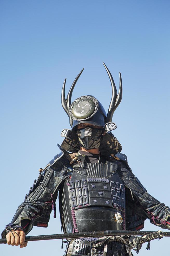miyajima, japan, 10 oktober 2016 - oidentifierad man klädd som en samuraj vid itsukushima-helgedomen på ön muyajima, japan. helgedomen är UNESCOs världsarv sedan 1996. foto