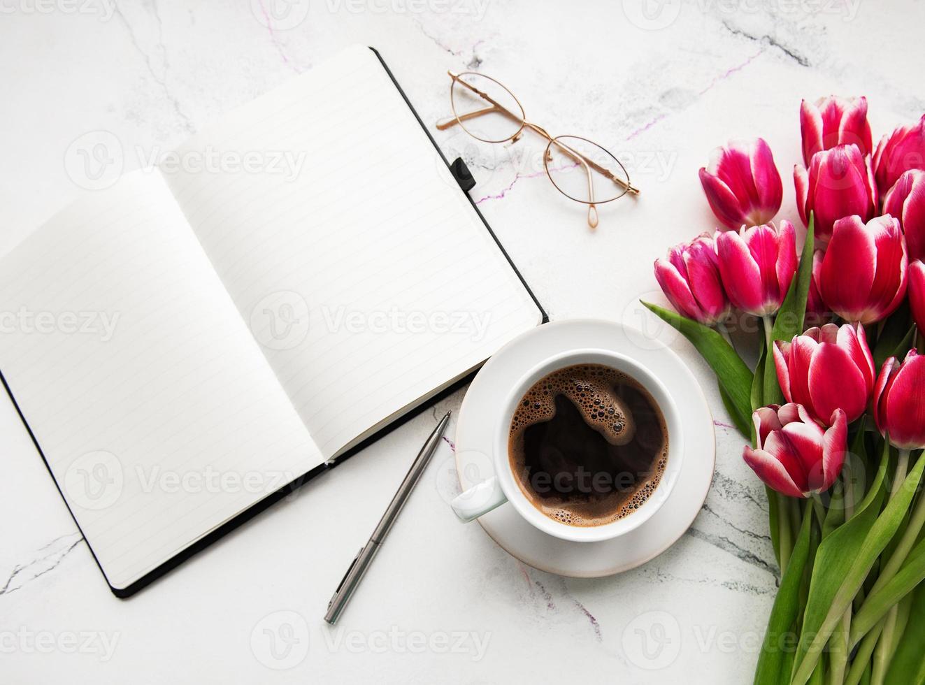 anteckningsbok, kopp kaffe och rosa tulpaner foto