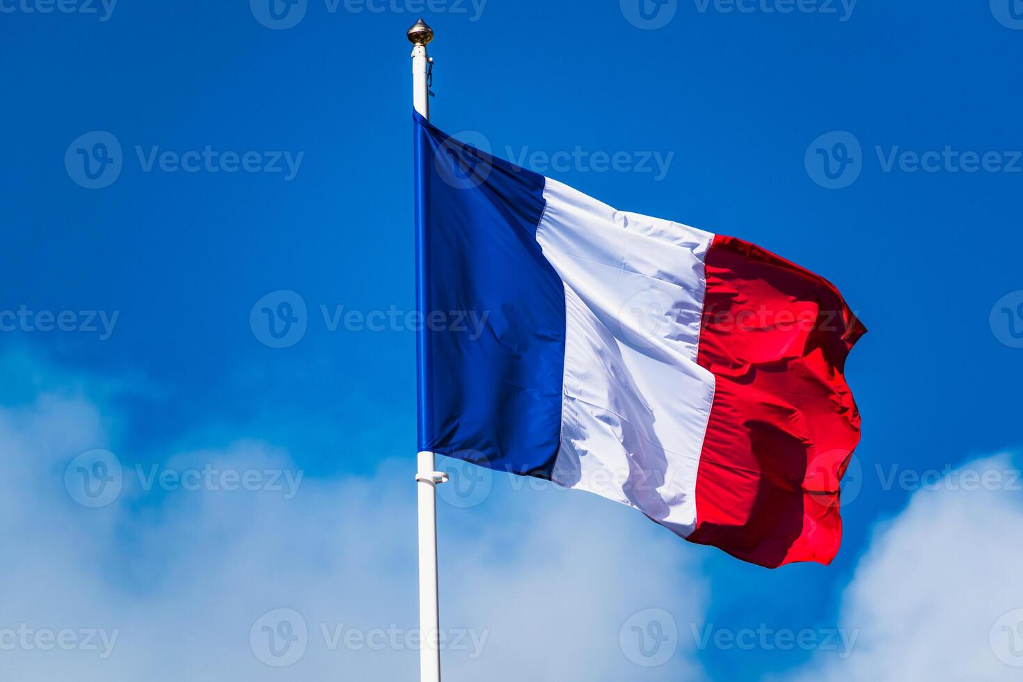 franska tricolor flagga fladdrande med stark vind och blå himmel foto