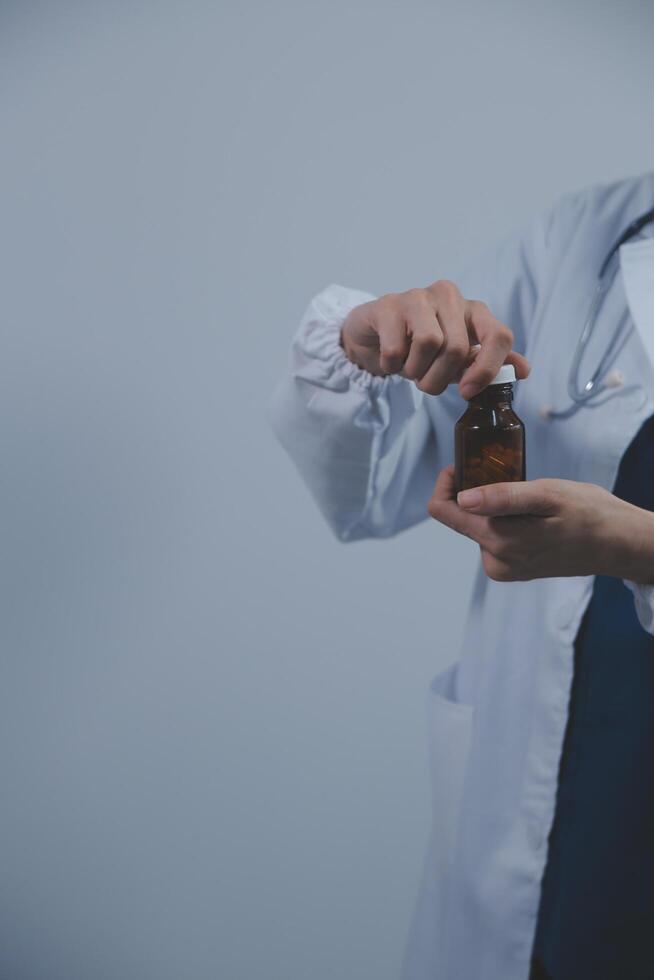 sydöst asiatisk medicinsk läkare innehav en flaska av biljard, leende isolerat vit bakgrund foto