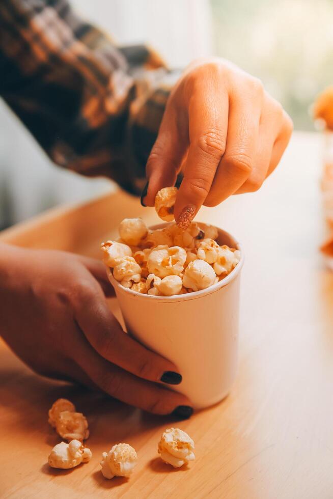 en kvinna innehav en skål av popcorn foto