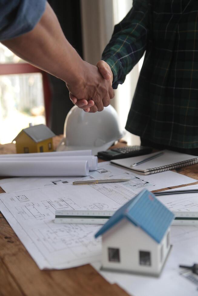 ingenjör och entreprenör Ansluta sig händer efter signering kontrakt, de är har en modern byggnad projekt tillsammans. framgångsrik samarbete team begrepp foto