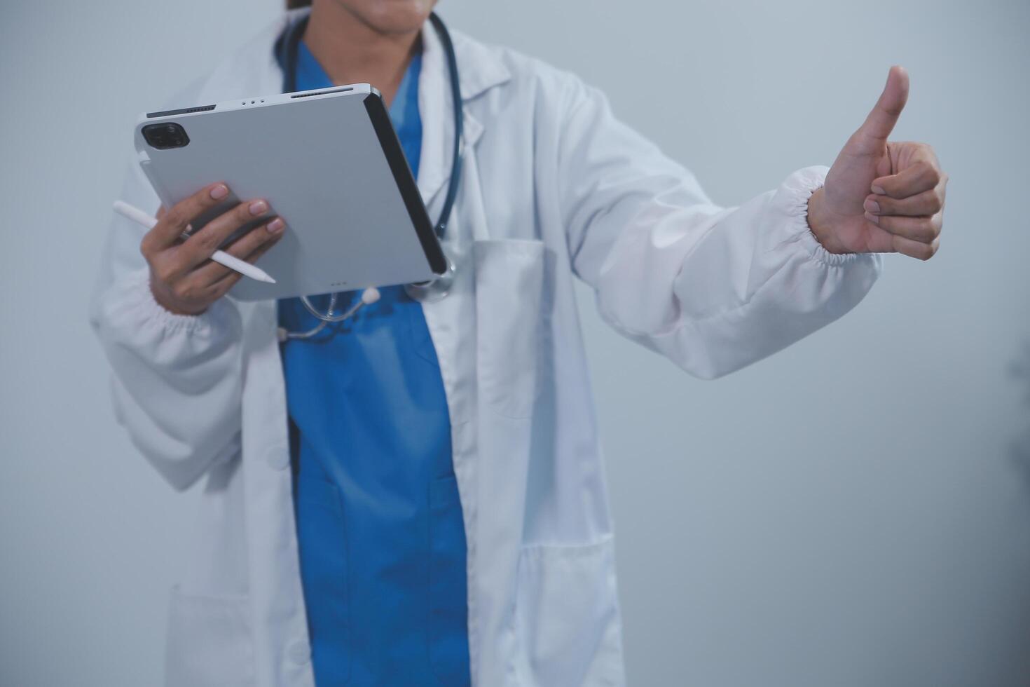 kvinna läkare använder sig av läsplatta dator medan stående hetero i sjukhus foto