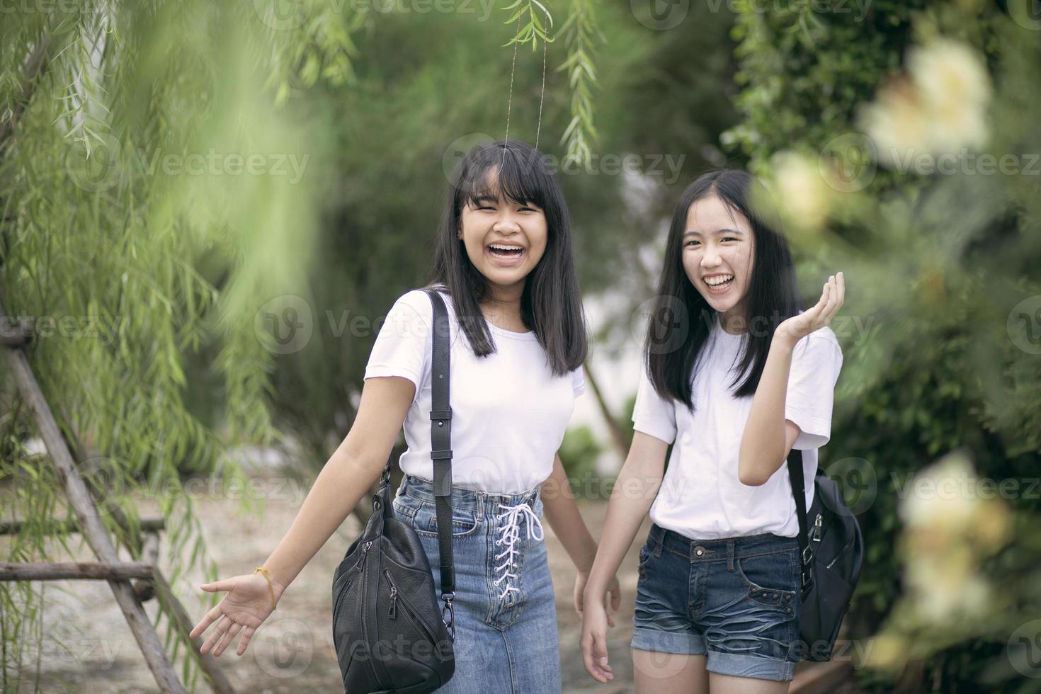 glad asiatisk tonåring skrattar i grön park foto
