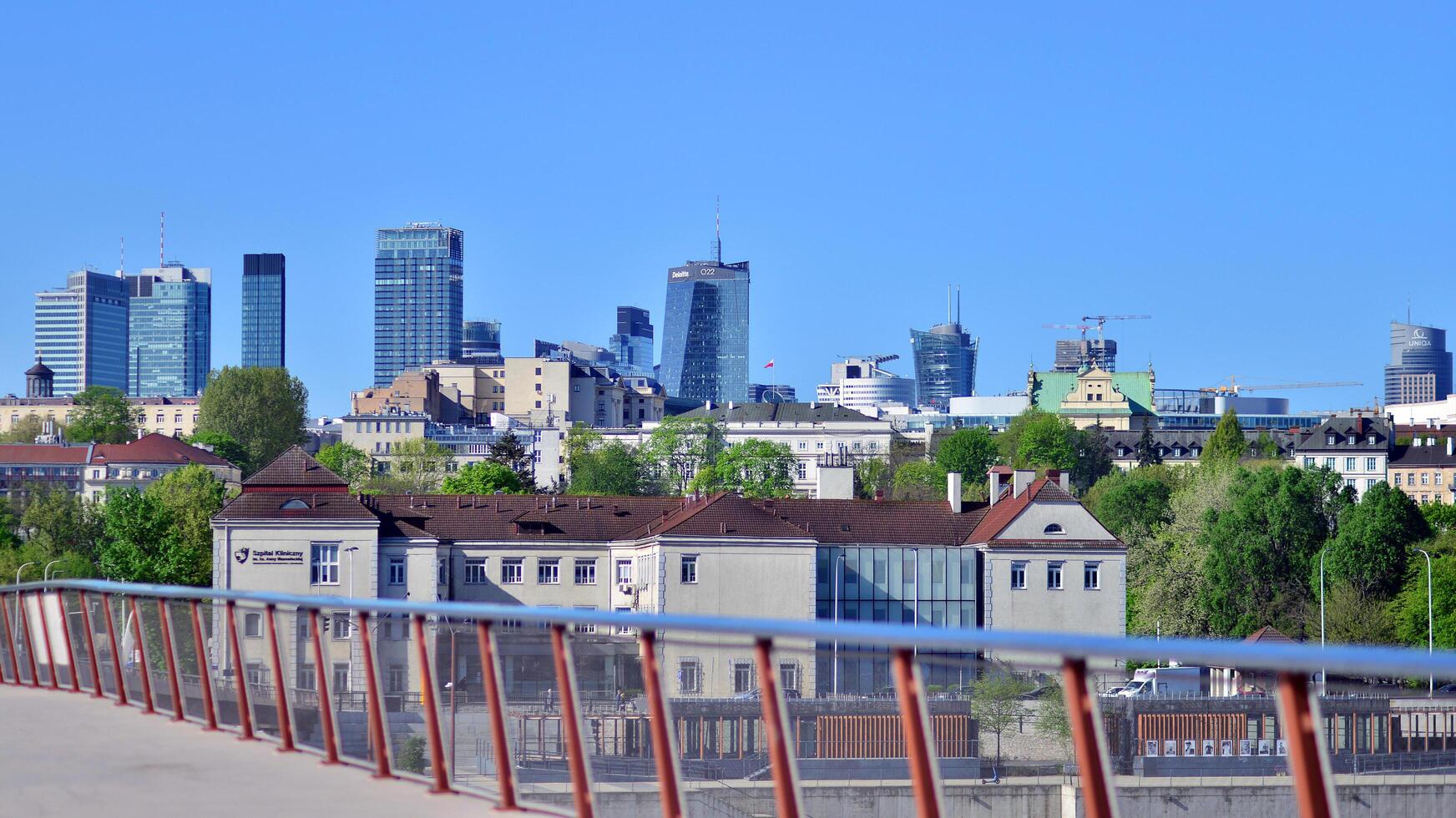 Warszawa, polen. 11 april 2024. bro över de vistula flod avsedd endast för fotgängare och cyklister. i de bakgrund, en panorama av de stad med skyskrapor. foto