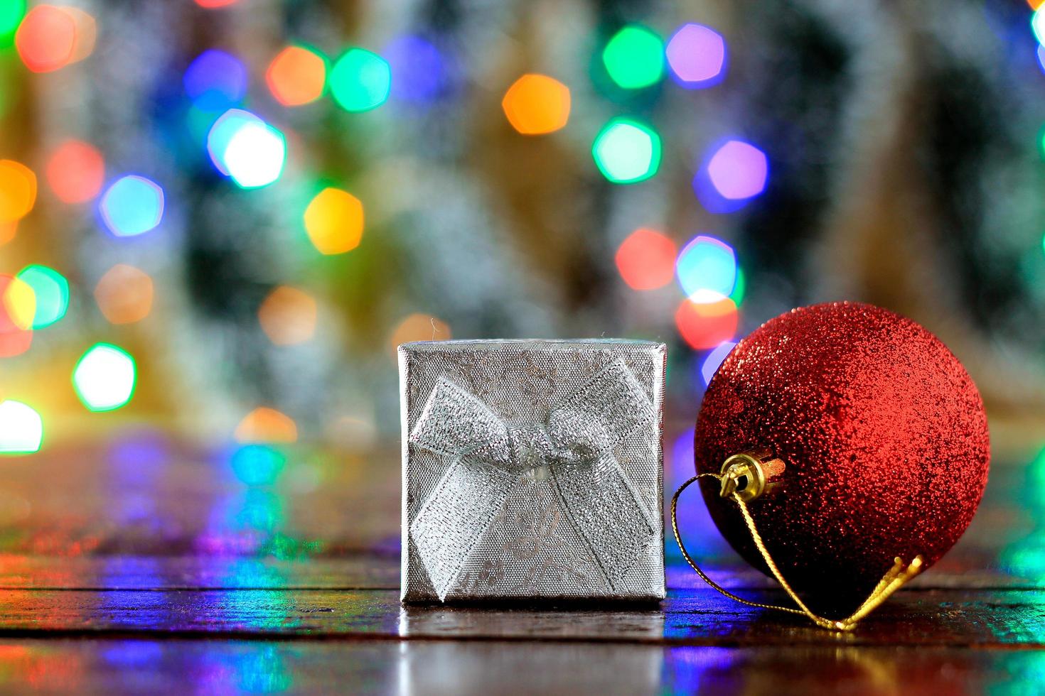 presentförpackning på träbord, juldekoration, suddiga ljus foto