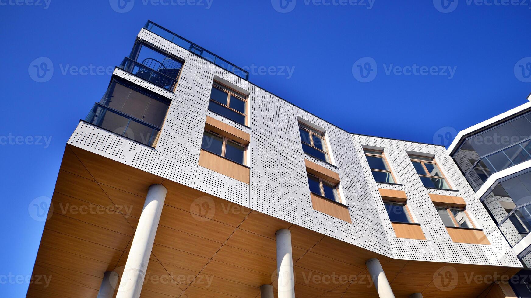 en lägenhet byggnad med en unik arkitektonisk lösning. en modern bostads- byggnad med en vit Fasad och stående på hög betong pelare. foto