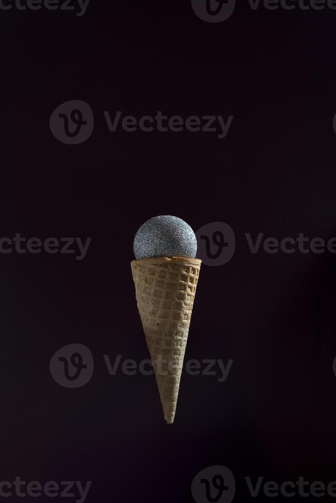 en mikrofon är placerad inuti av ett is grädde kon. de kon är upside ner och de mikrofon är suspenderad i de luft. foto