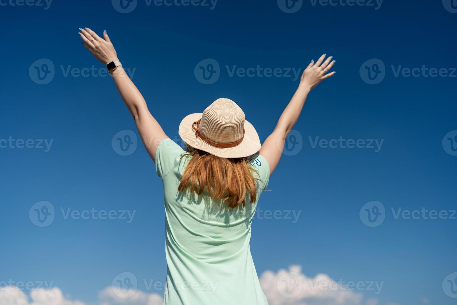 kvinna turist himmel. Lycklig resande kvinna i hatt åtnjuter semester Uppfostrad henne händer upp foto