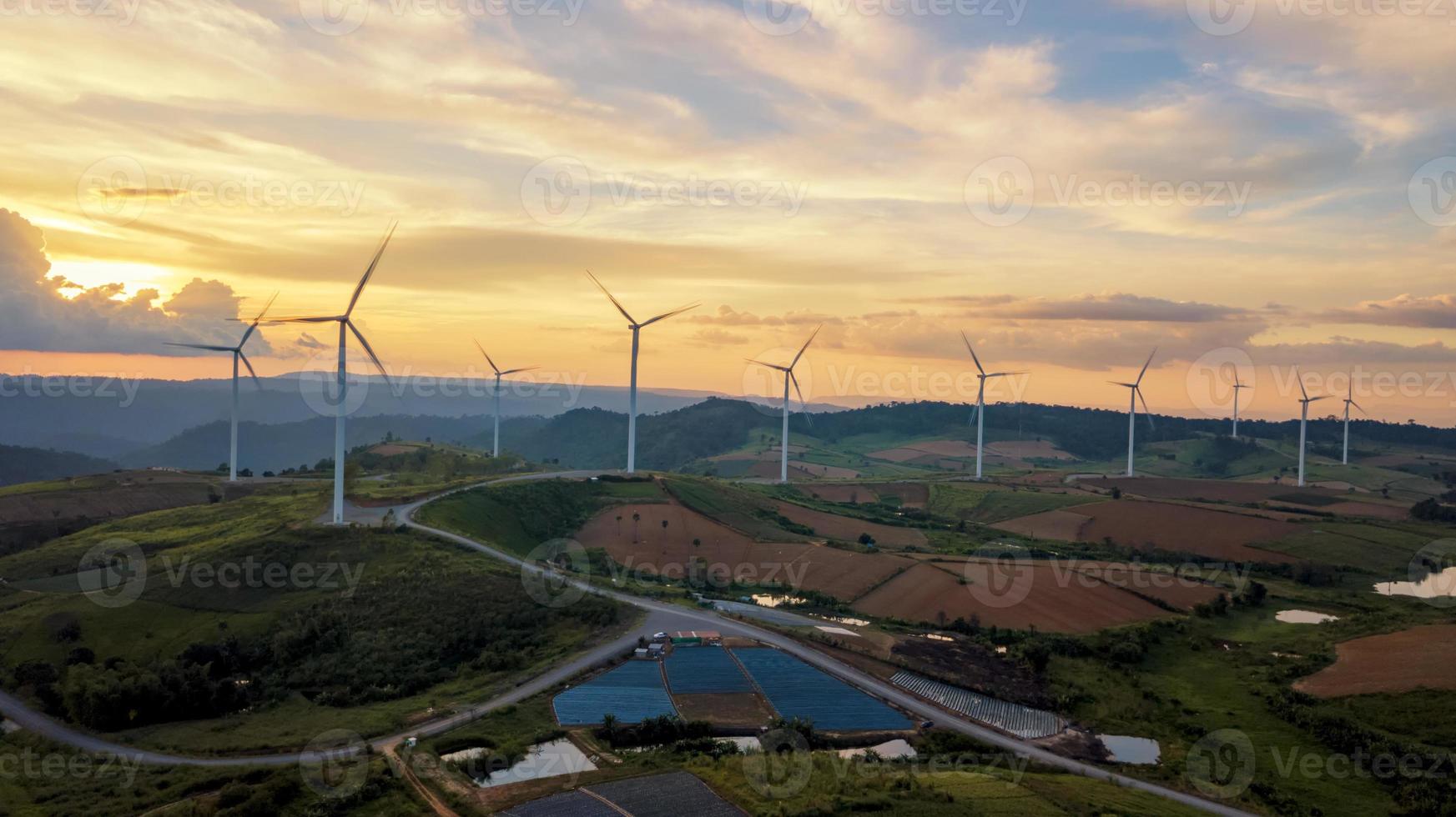 solnedgång landskap vindkraftverk gård ren grön energi för elektrisk detta är flygfoto som flyger från drönare foto