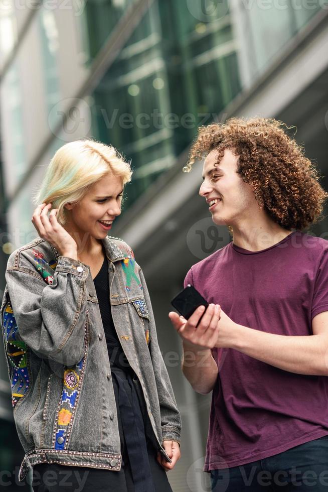 lyckligt par som använder smartphone i urban bakgrund. foto