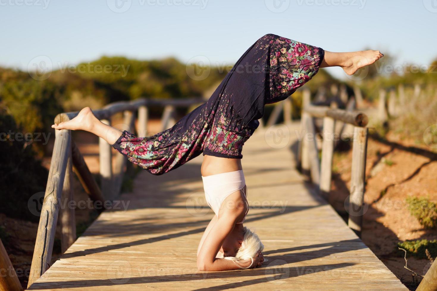 kaukasisk kvinna utövar yoga på träbro. foto