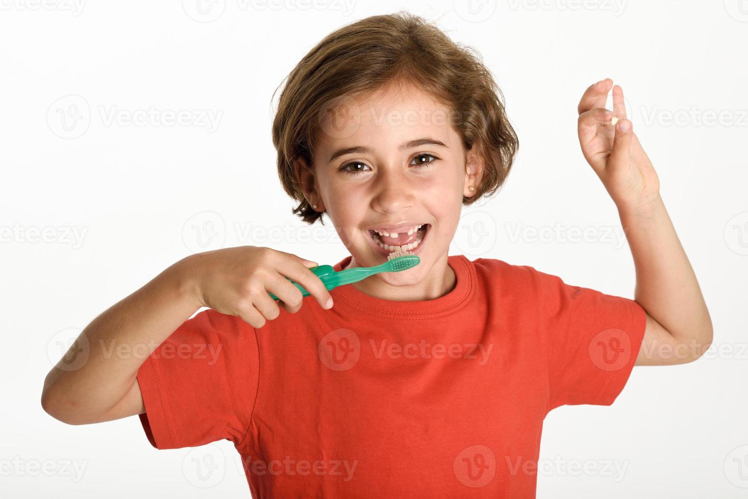 liten flicka borstar tänderna med en tandborste. foto