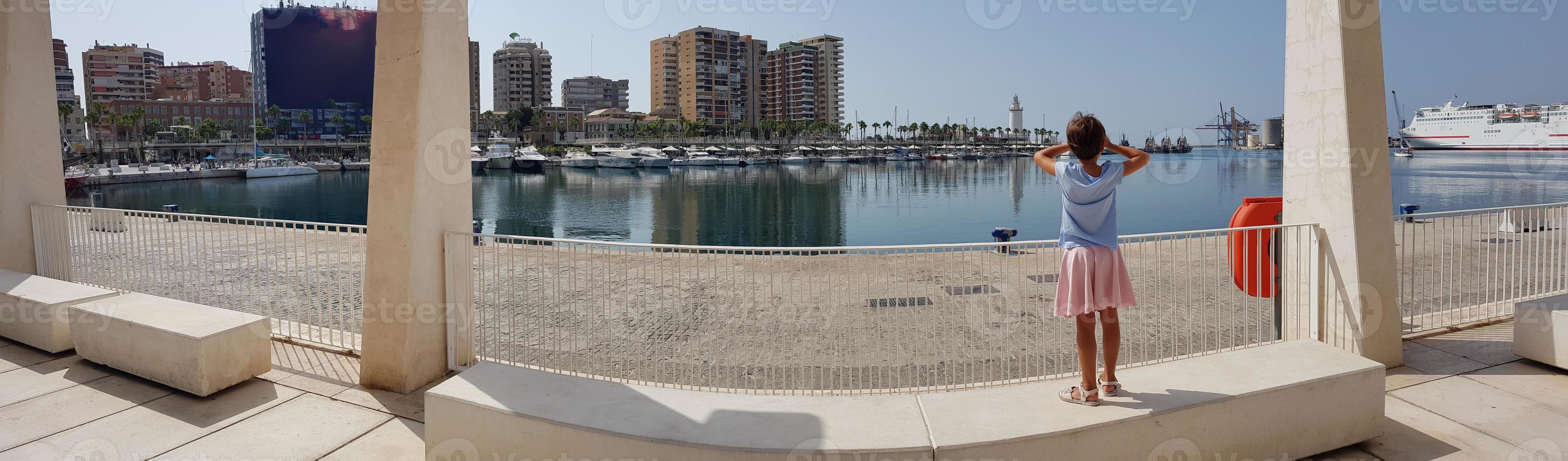 liten flicka tittar på hamnen i Malaga foto