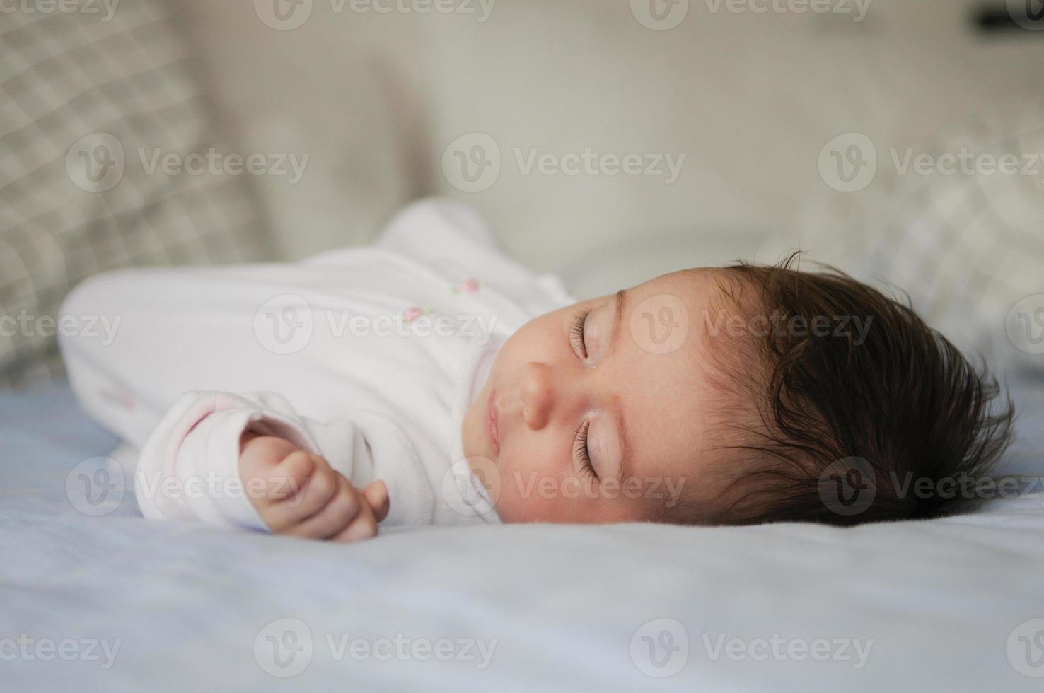 nyfödd flicka sover på blå lakan foto