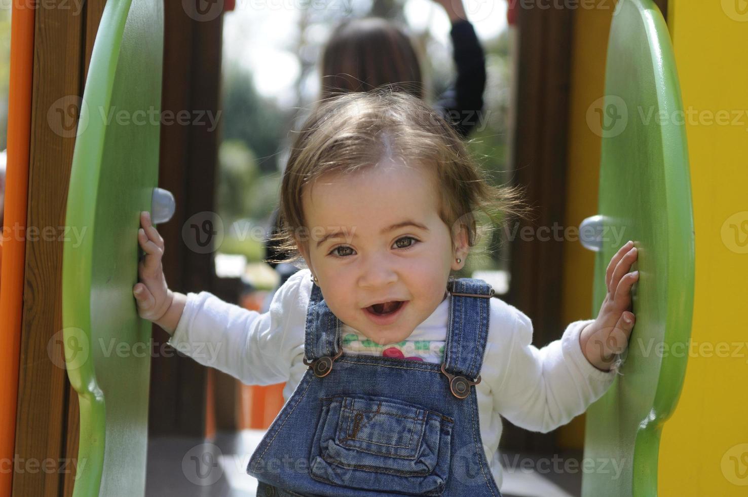 liten flicka som leker i en urban lekplats. foto
