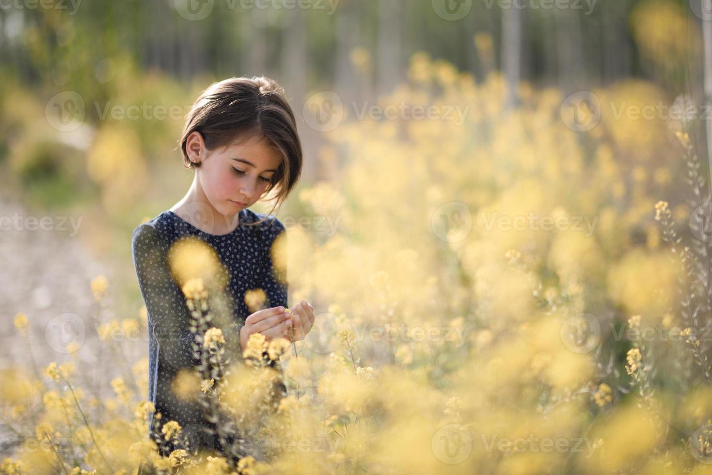 liten flicka går i naturfältet bär vacker klänning foto