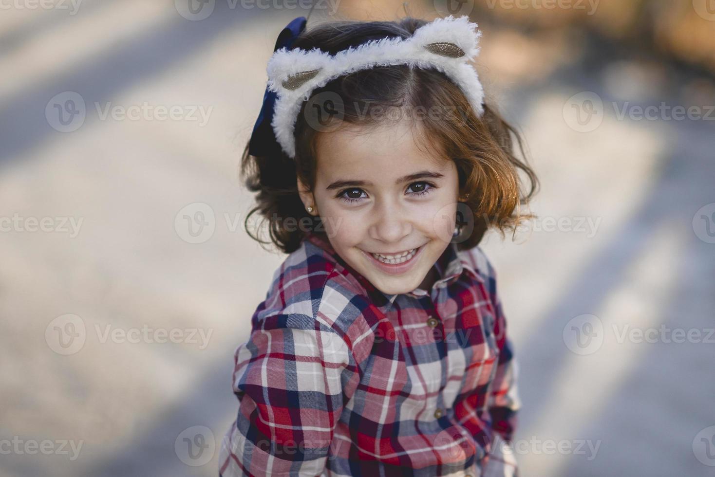 bedårande liten flicka som ler utomhus. foto