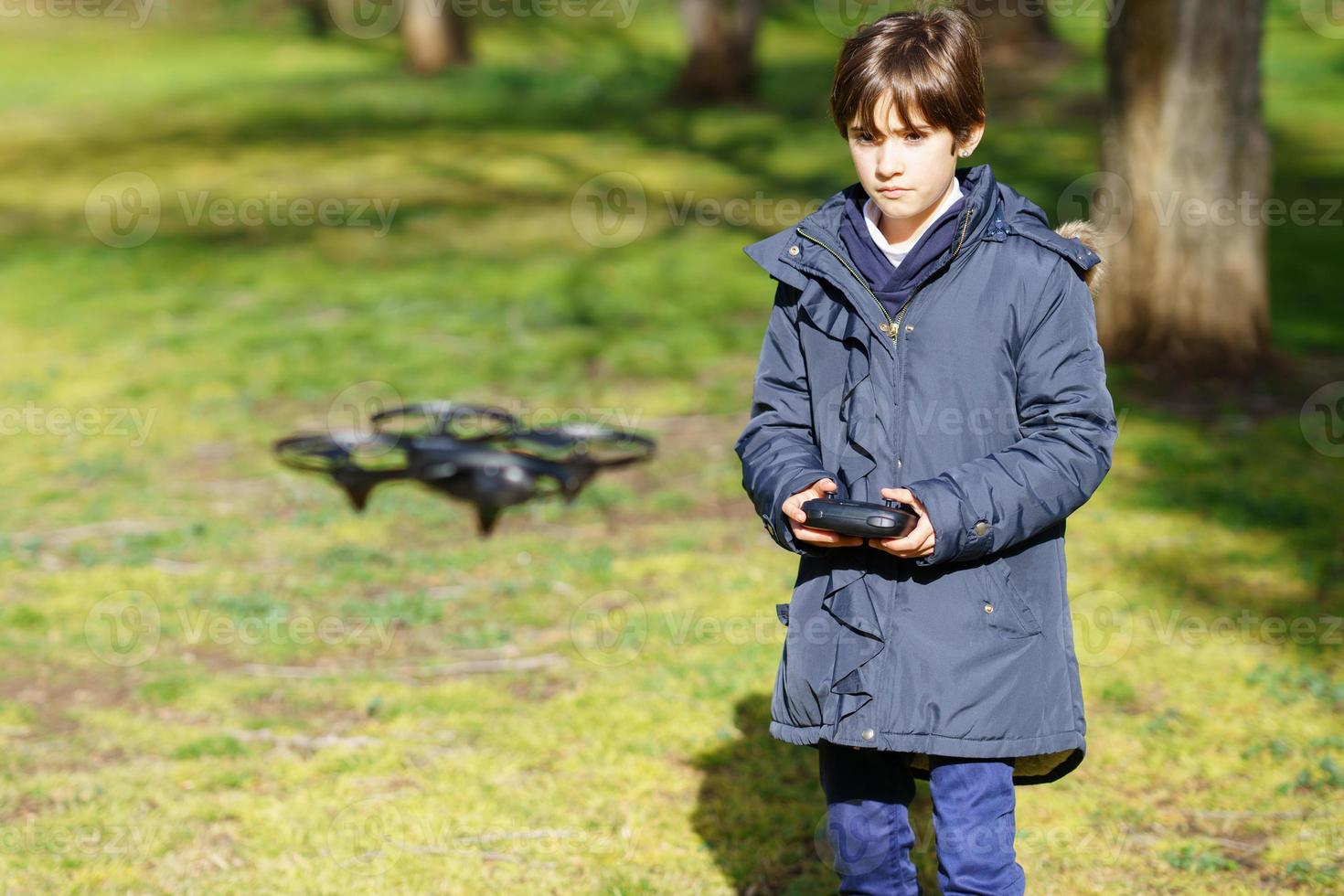 nioårig flicka som använder en leksaksdrönare som flyger med fjärrkontroll foto