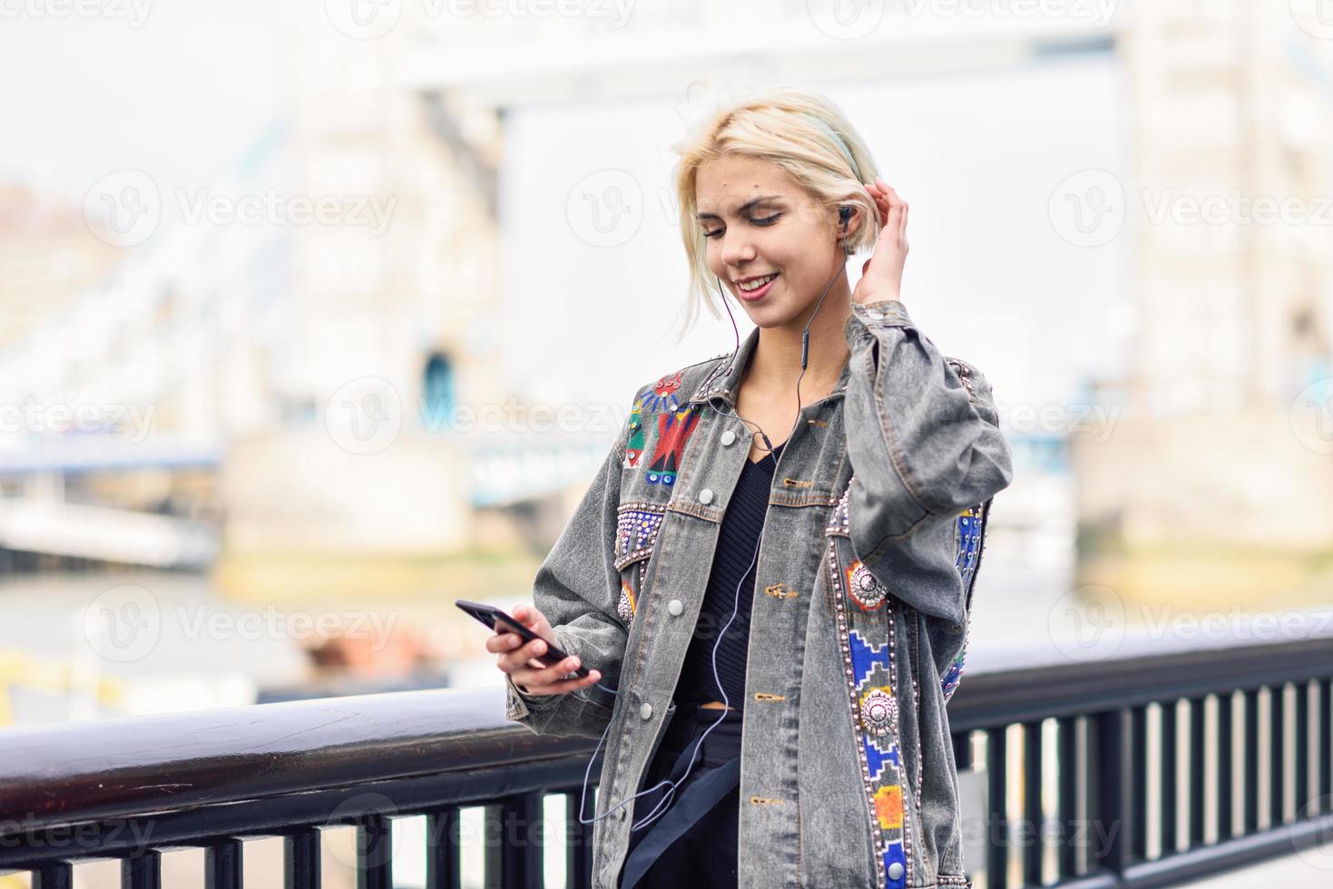 ung kvinna lyssnar på musik i urban bakgrund. foto