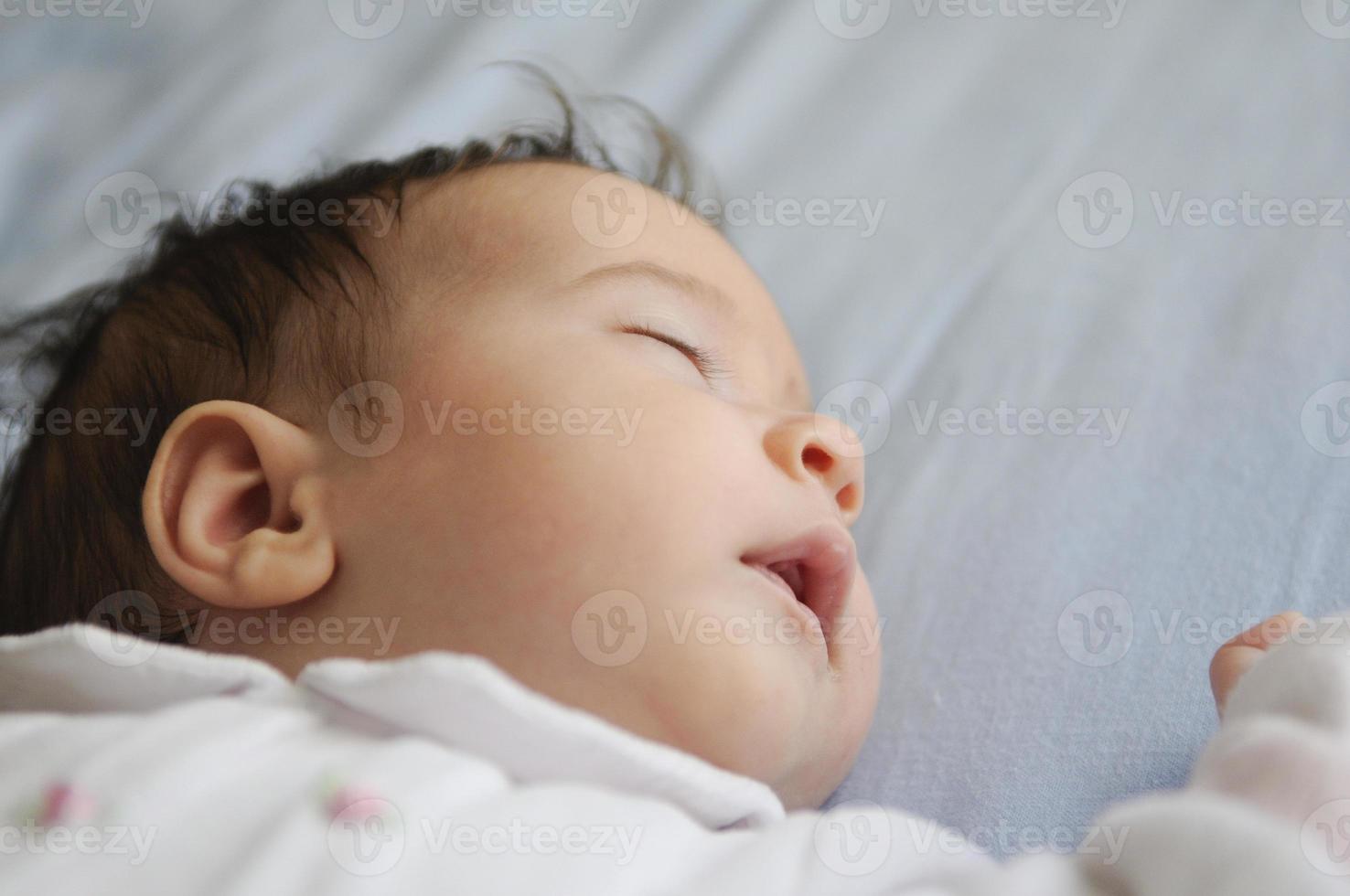 nyfödd flicka sover på blå lakan foto