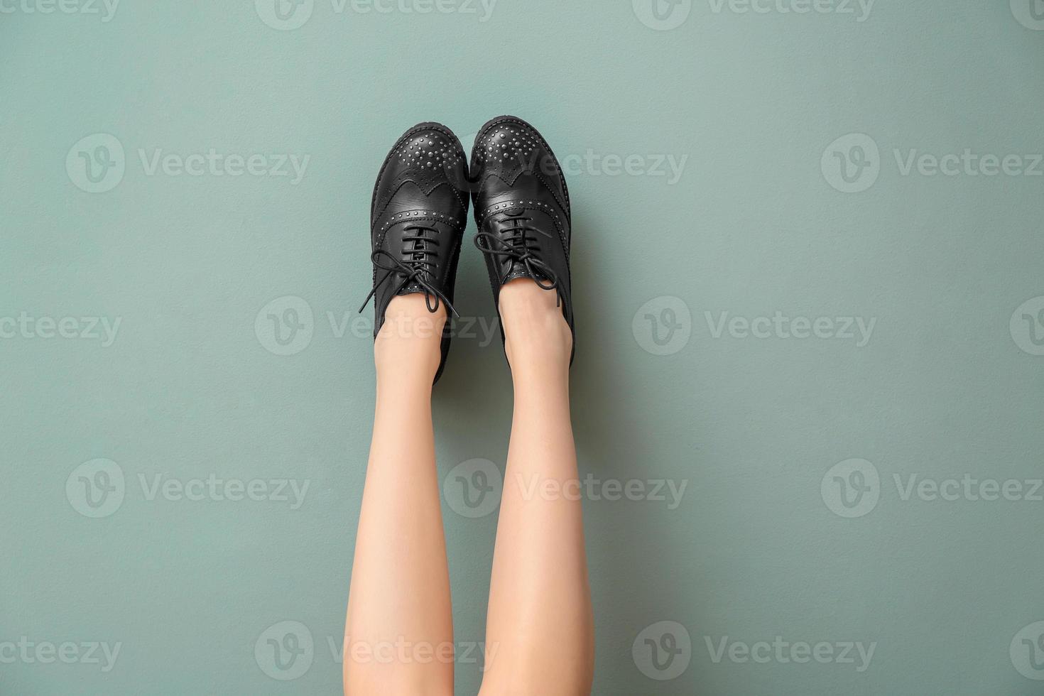 ben av ung kvinna i snygga casual skor på färgbakgrund foto