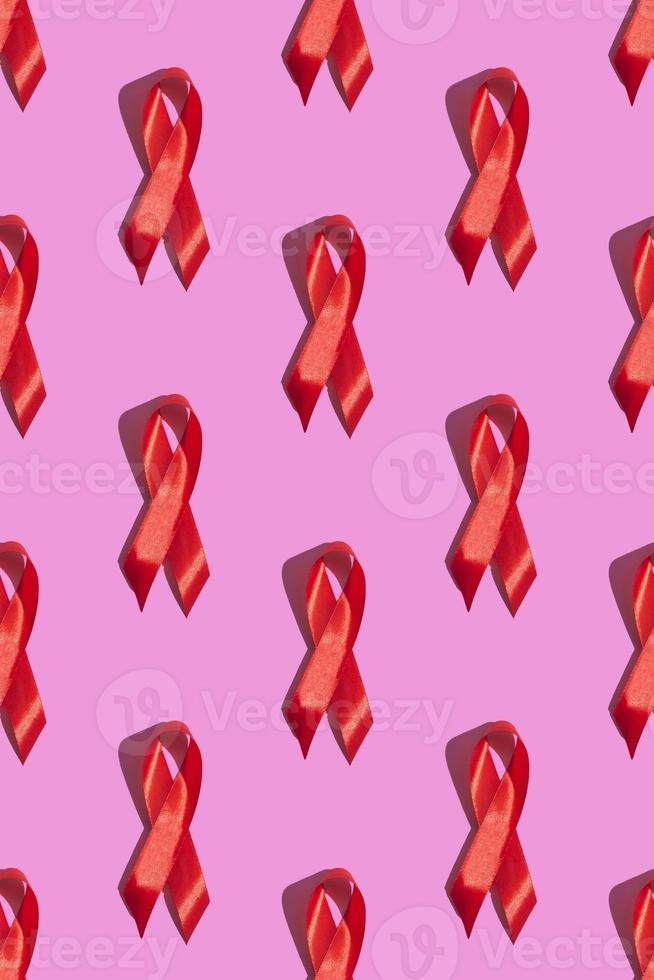 internationella aidsdagen. rött band med en hård skugga på en rosa bakgrund. hjälpmedel medvetenhet koncept. vertikal. mönster foto