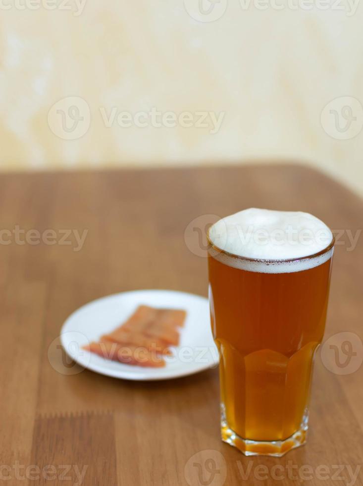 öl i ett glas på bordet och en tallrik med fisk foto