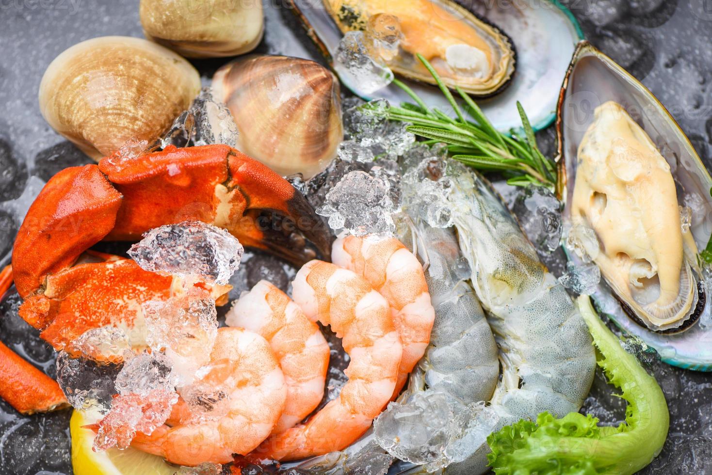 färsk rå skaldjursbuffé med citron rosmarin ingredienser ört och kryddor - skaldjur på is frysta med räkor räkor krabba klor skalmussla och musslor på restaurangen foto