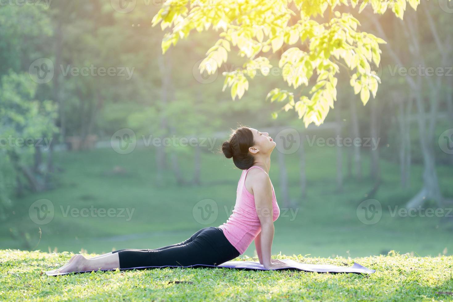 ung vacker asiatisk kvinna som utövar yoga foto