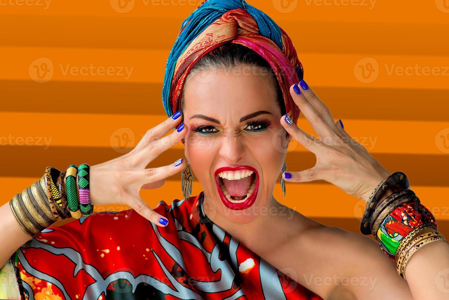 porträtt av skrikande ung attraktiv kvinna sångerska i afrikansk stil på färgglad bakgrund foto