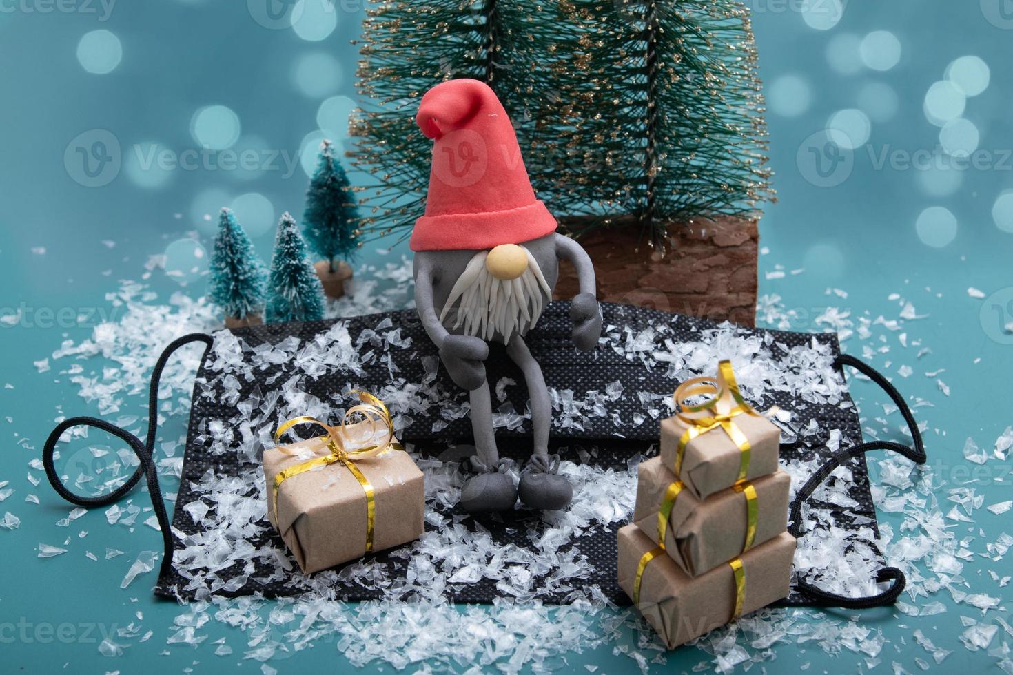 skandinavisk gnome bär en snötäckt medicinsk mask med julklappar foto