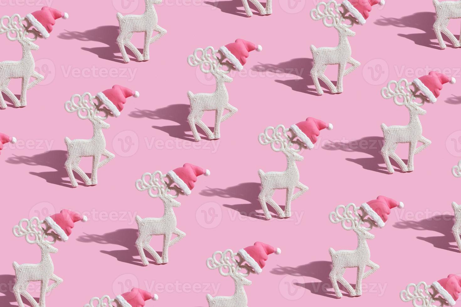 mönster med en glamorös ren i en tomtehatt på en rosa bakgrund foto