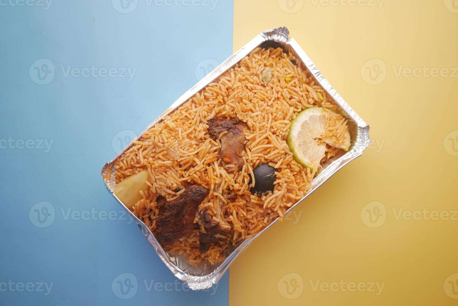 fårkött biryani måltid i en plast take away box på färgbakgrund foto