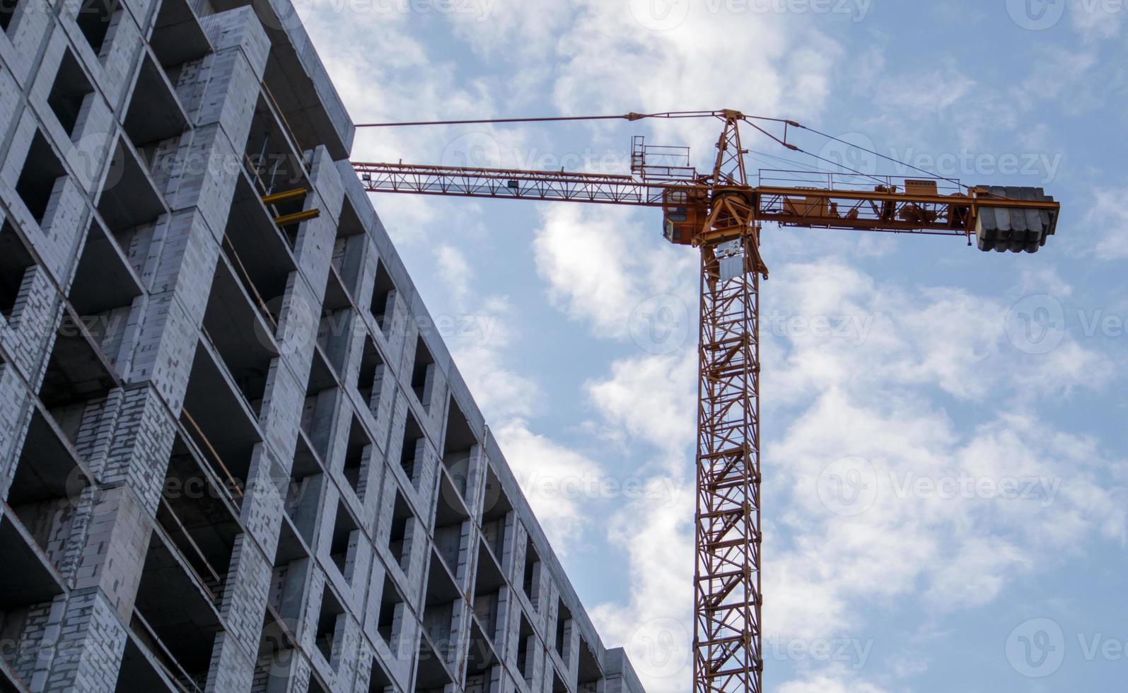 stor byggarbetsplats. processen för kapitalkonstruktion av ett höghus bostadskomplex. betongbyggnad, konstruktion, industriplats. industriell kran på bakgrunden av himlen. foto