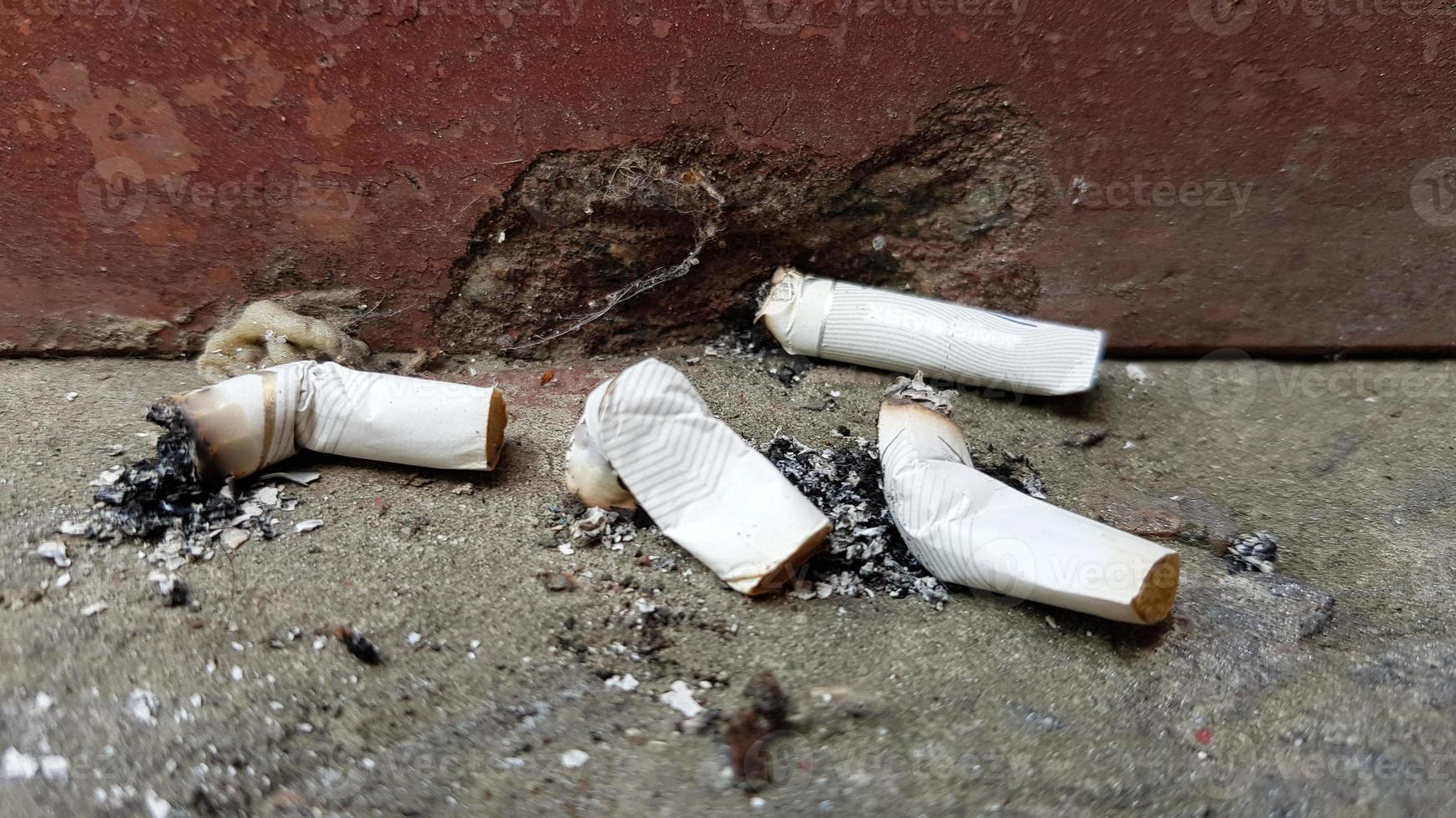 mycket cigarettfimpar. orsaken till lungcancer. många använde cigarettfimpar som skräp foto