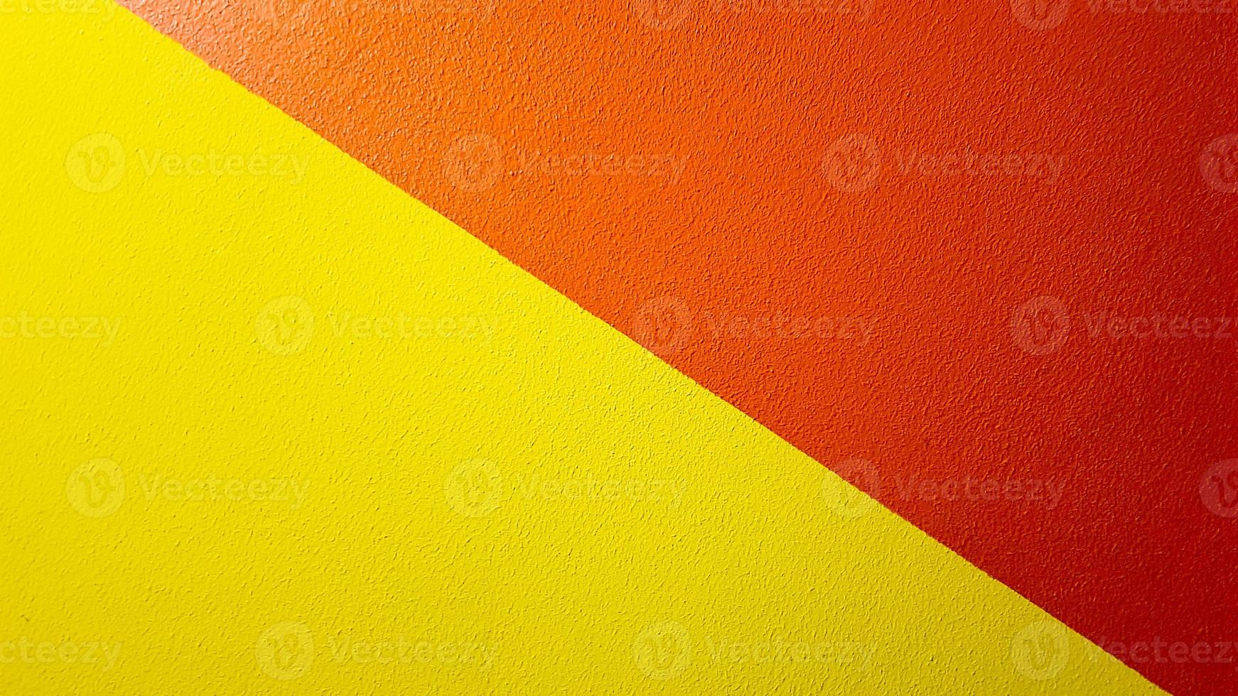 röd och gul målad vägg textur abstrakt grunge bakgrund med kopia utrymme. abstrakt geometriskt mönster på väggen. väggen är uppdelad i bårder i olika färger foto