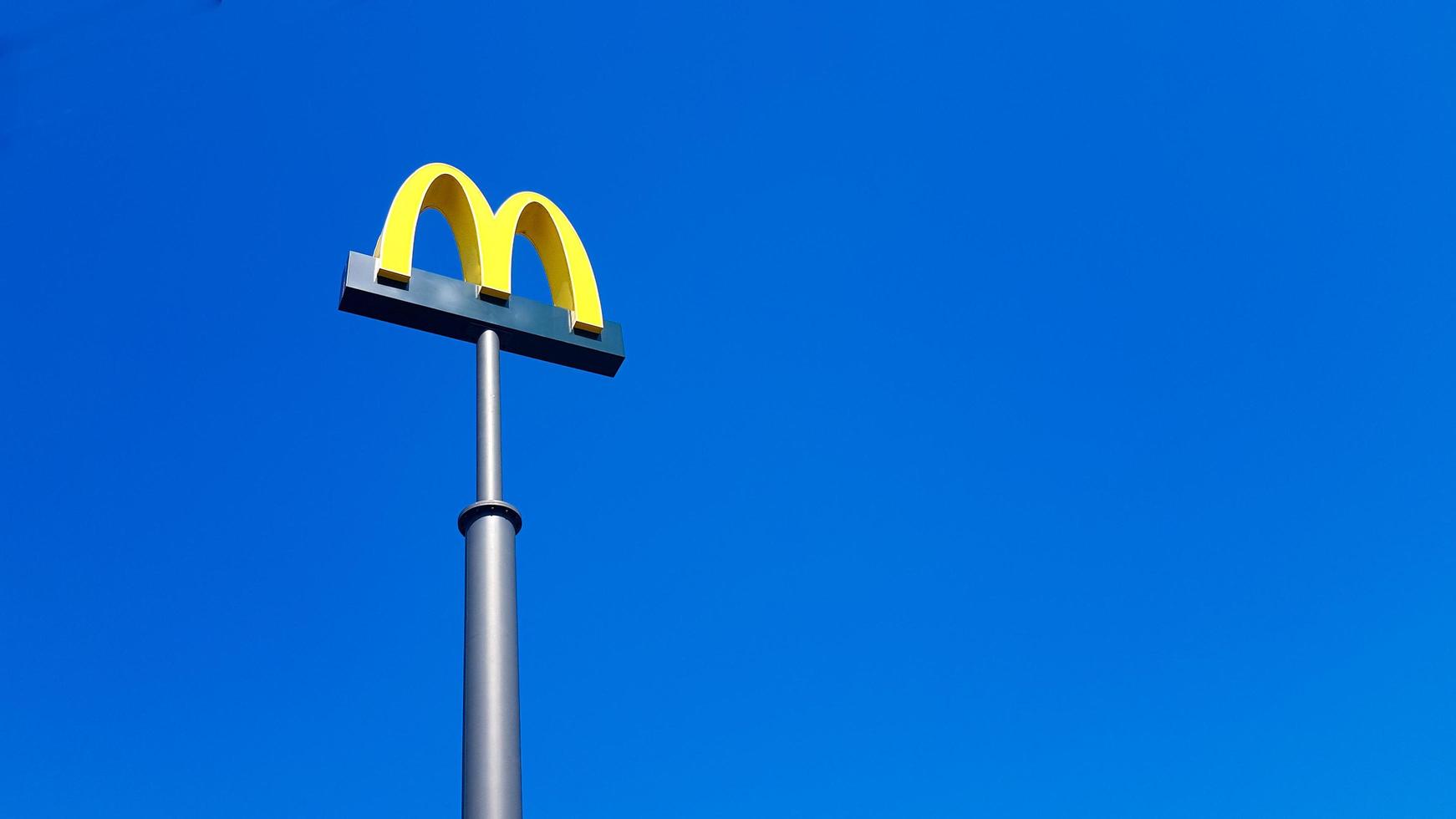 Ukraina, Kiev - 23 augusti 2019. McDonalds logotyp mot himlen. mcdonald's corporation är världens största kedja av hamburger snabbmatsrestauranger. foto