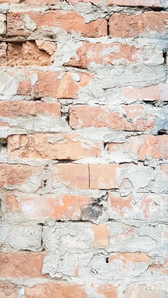 bakgrund av röd tegelvägg nära mönsterstruktur. ett provfoto av en vertikal vägg med tegel och cement. vertikalt foto för sociala nätverk.