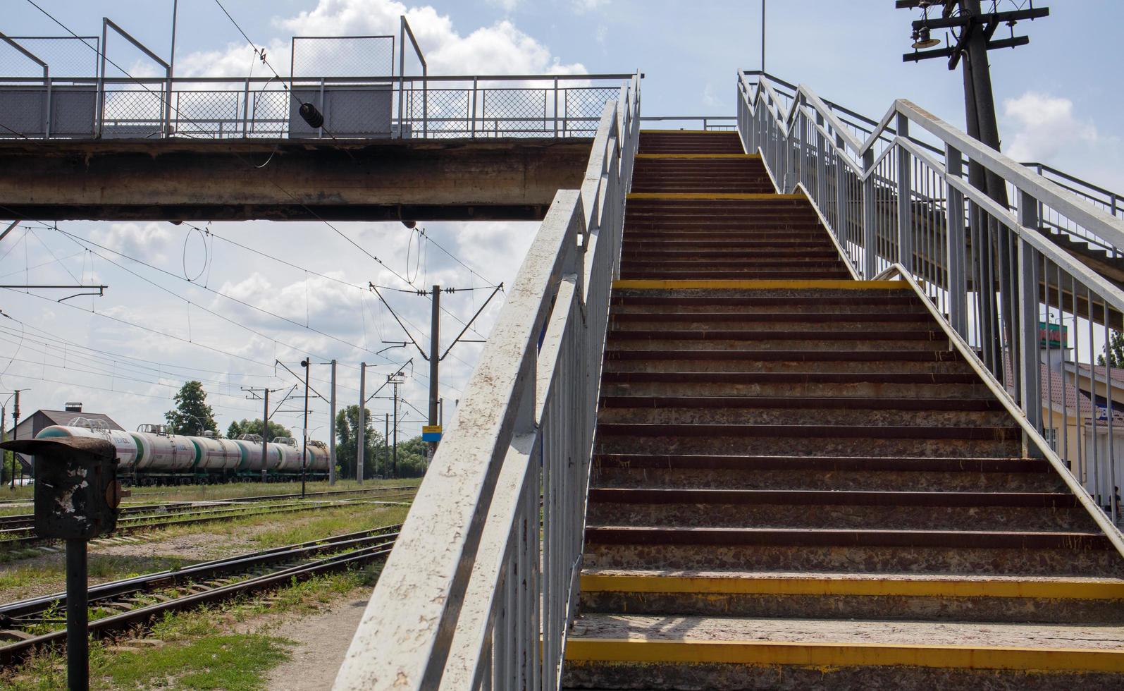 järnvägsbro med trappsteg, med imponerande trappsteg i perspektiv. övergångsställe. brotrappor som förbinder en plattform med en annan vid tågstationen. Ukraina, Kiev - 19 augusti 2021. foto