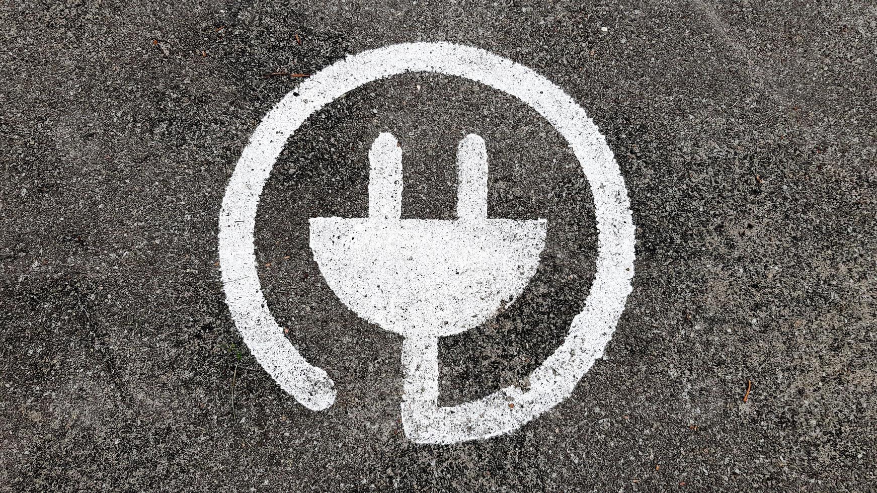 elektrisk laddare symbol för bilar, på en allmän parkering foto