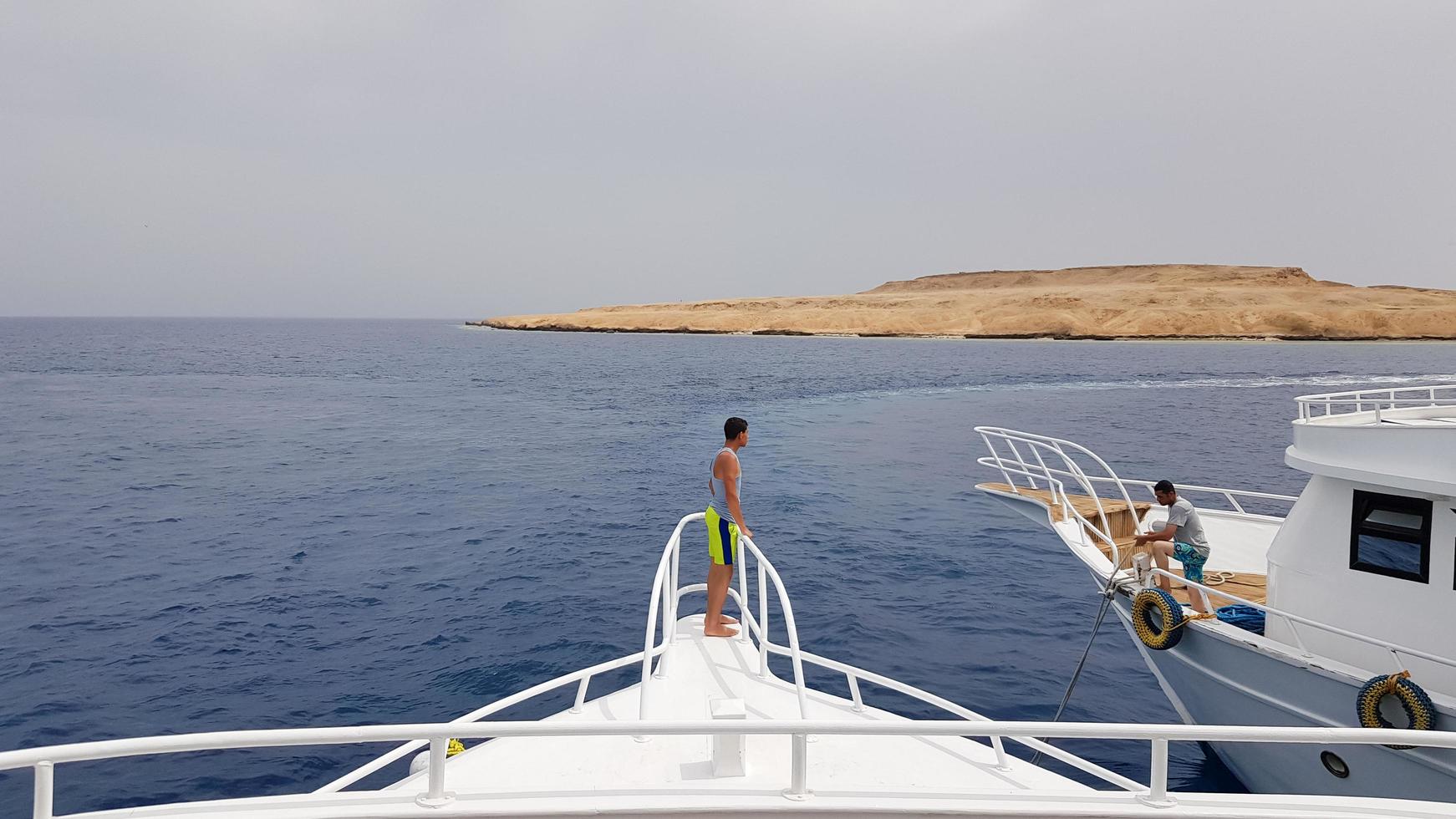 egypten, sharm el sheikh - 20 september 2019. en vacker utsikt från däcket på ett kryssningsfartyg i röda havet i egypten. landskap av den egyptiska klippiga kusten av staden med en yacht. foto