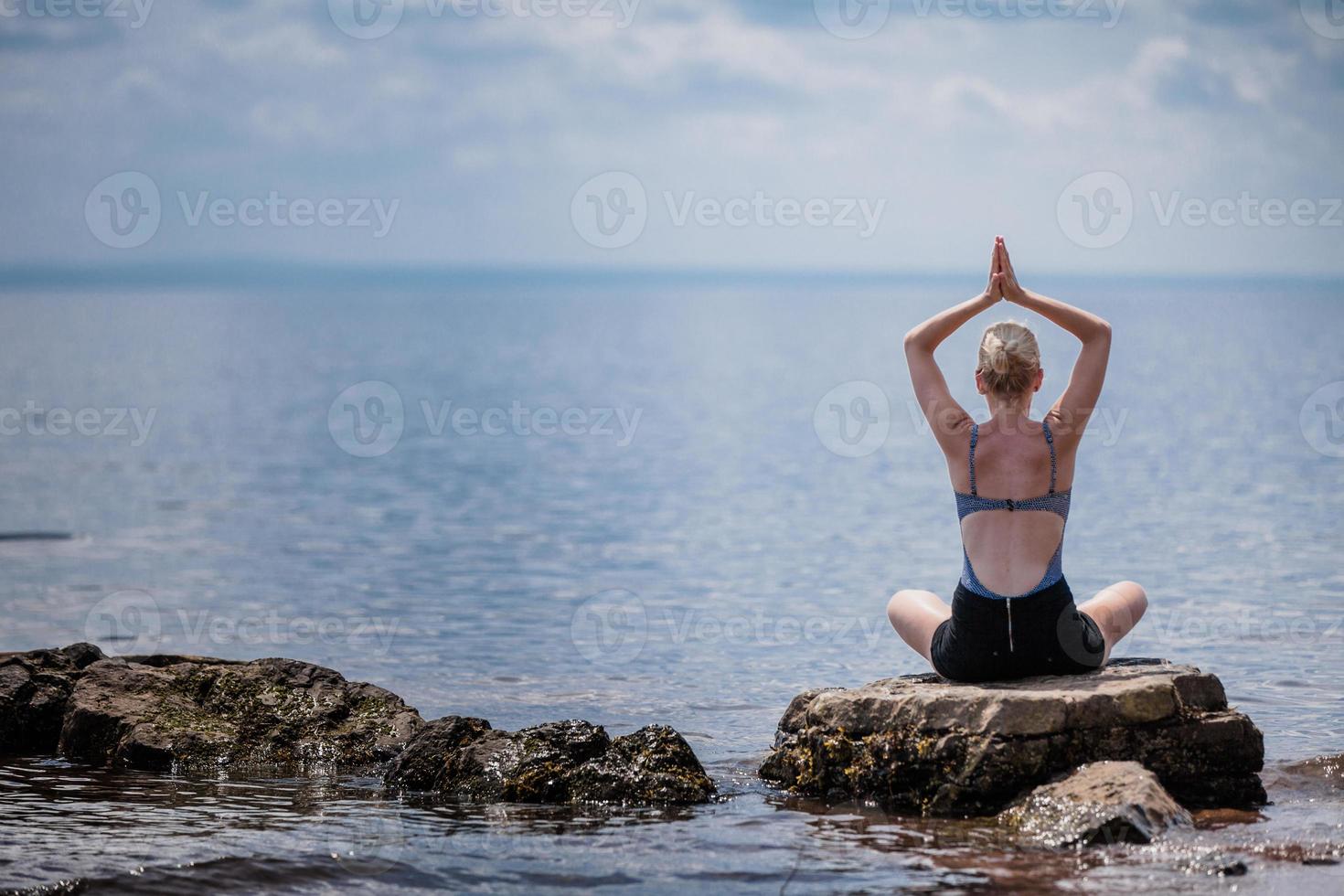 ung kvinna gör lotus yoga position foto